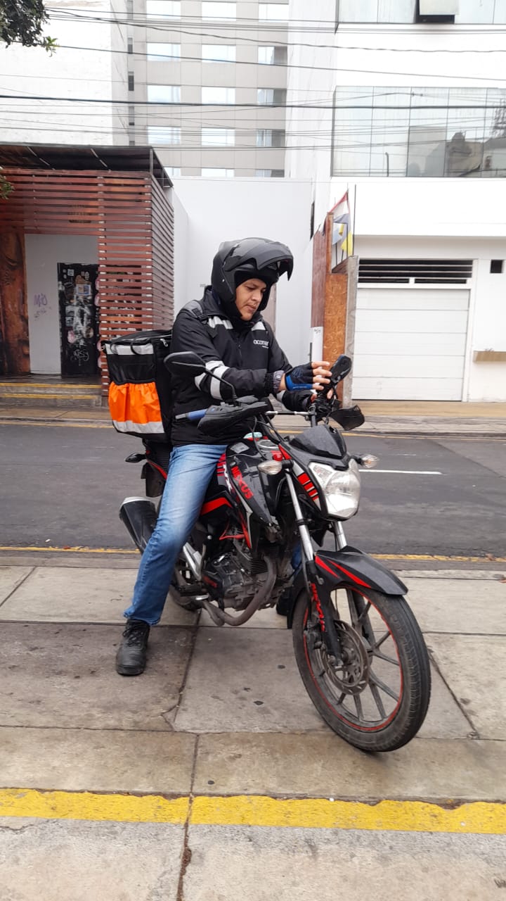 Motorizado ACORRER en ruta consultando el pedido
